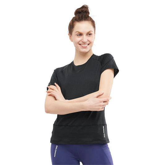 Woman wearing a black athletic shirt with a visible brand logo on a white background