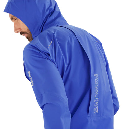 Person wearing a blue Salomon raincoat on a white background