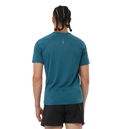 Person wearing a teal athletic shirt and black shorts on a white background