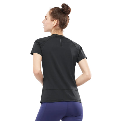 Woman wearing a black athletic shirt and purple leggings on a white background